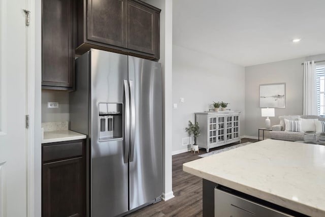 14712 S Azalia Cir, Plainfield, IL 60544 - kitchen with stainless steel fridge with ice dispenser, dark brown cabinetry, dark wood finished floors, light stone counters, and baseboards