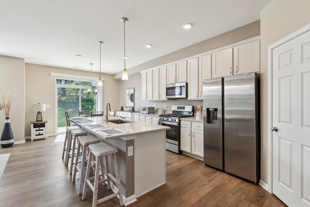 12654 S Talbot Cir, Plainfield, IL 60585 - kitchen featuring appliances with stainless steel finishes, a sink, a kitchen island with sink, white cabinetry, and dark wood-style floors