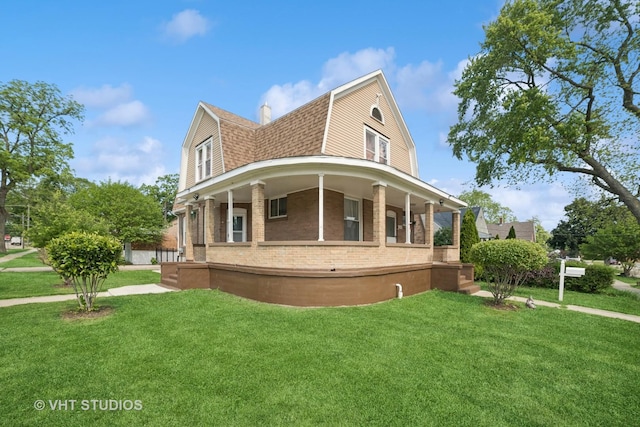 558 N Crystal St, Elgin, IL 60123 - back of property featuring a gambrel roof, covered porch, brick siding, and a lawn