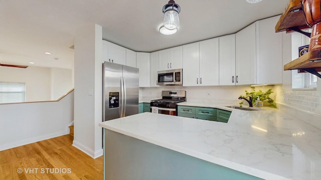 3649 W Cornelia Ave Unit C, Chicago, IL 60618 - kitchen featuring stainless steel appliances, a sink, light wood-style floors, and white cabinetry