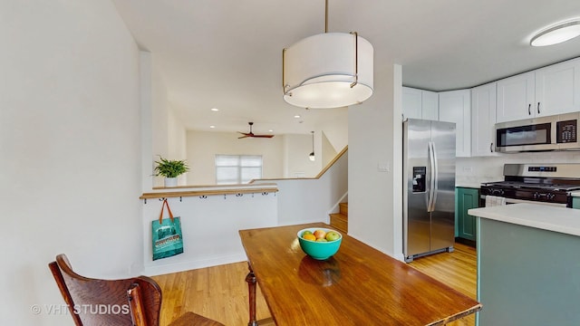 3649 W Cornelia Ave Unit C, Chicago, IL 60618 - kitchen featuring appliances with stainless steel finishes, light wood-style flooring, white cabinets, light countertops, and baseboards