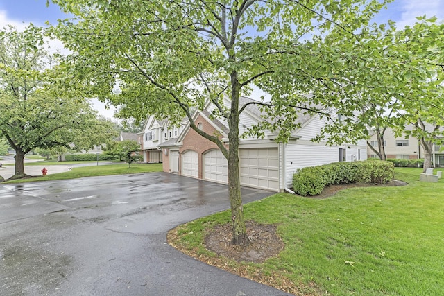 1604 Newburn Ct Unit D1, Wheeling, IL 60090 - view of side of home featuring asphalt driveway, a yard, and an attached garage