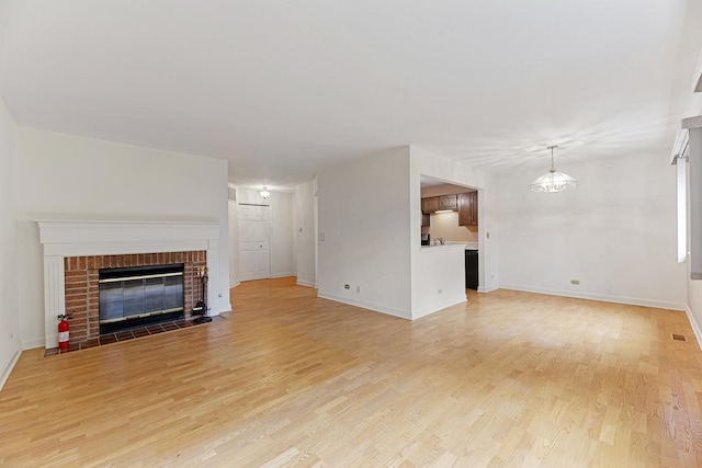 1604 Newburn Ct Unit D1, Wheeling, IL 60090 - unfurnished living room with light wood-type flooring, baseboards, and a brick fireplace