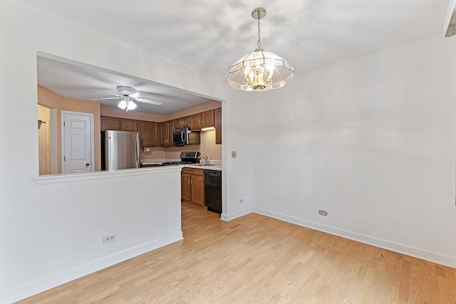 1604 Newburn Ct Unit D1, Wheeling, IL 60090 - kitchen with stainless steel appliances, a chandelier, baseboards, and light wood-style floors