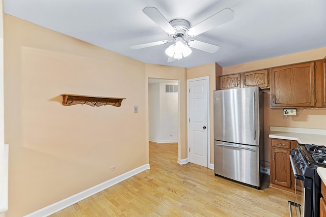 1604 Newburn Ct Unit D1, Wheeling, IL 60090 - kitchen featuring freestanding refrigerator, gas stove, brown cabinets, and baseboards