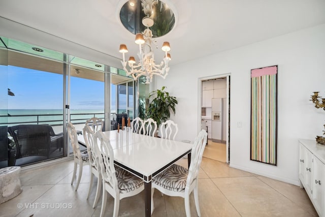 1300 N Lake Shore Dr Unit 18D, Chicago, IL 60610 - dining room featuring a chandelier, a water view, light tile patterned flooring, and baseboards