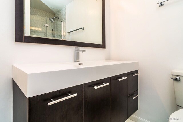 100 E Walton St Unit 22H, Chicago, IL 60611 - bathroom featuring vanity, a shower with door, and toilet