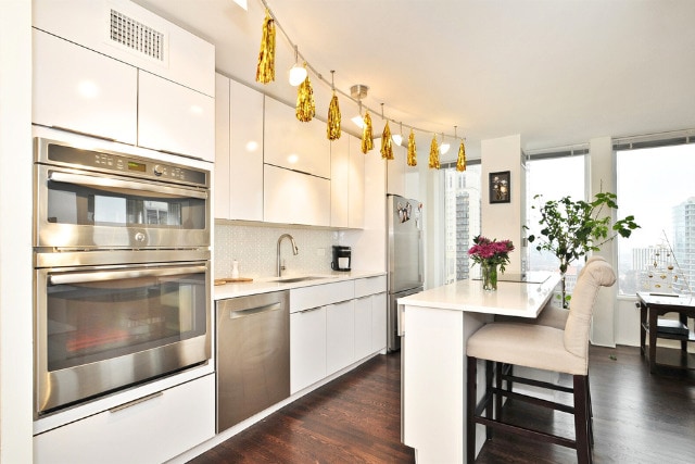 100 E Walton St Unit 22H, Chicago, IL 60611 - kitchen featuring stainless steel appliances, light countertops, a breakfast bar, and a sink