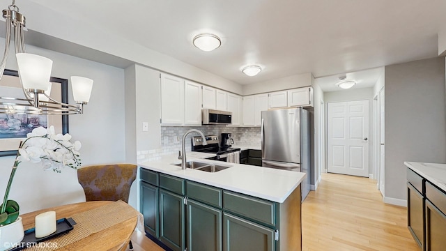 5400 Walnut Ave Unit 201, Downers Grove, IL 60515 - kitchen featuring appliances with stainless steel finishes, light countertops, backsplash, light wood-style floors, and a peninsula