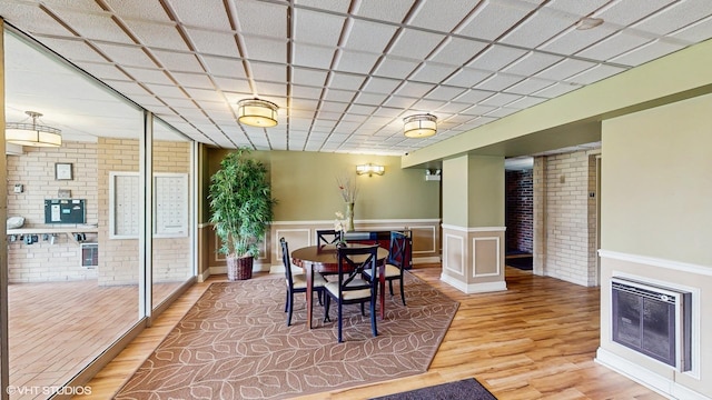 5400 Walnut Ave Unit 201, Downers Grove, IL 60515 - dining area featuring brick wall, wood finished floors, and wainscoting