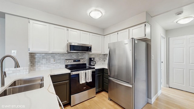 5400 Walnut Ave Unit 201, Downers Grove, IL 60515 - kitchen with stainless steel appliances, light wood-type flooring, white cabinets, and light stone counters
