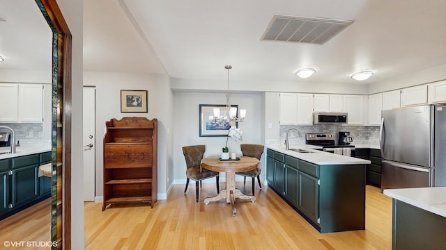 5400 Walnut Ave Unit 201, Downers Grove, IL 60515 - kitchen featuring stainless steel appliances, white cabinetry, light countertops, decorative backsplash, and light wood-style flooring