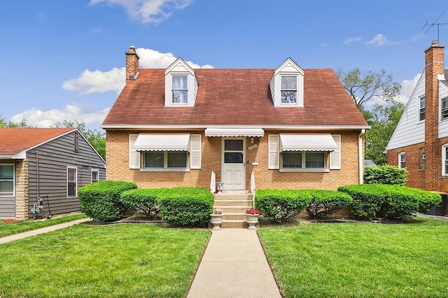 17715 Roy St, Lansing, IL 60438 - cape cod-style house featuring brick siding, a front yard, a chimney, and entry steps
