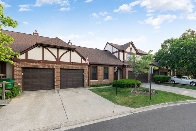 3072 Carlton Ct, Westchester, IL 60154 - tudor-style house with driveway, brick siding, a front lawn, stucco siding, and an attached garage