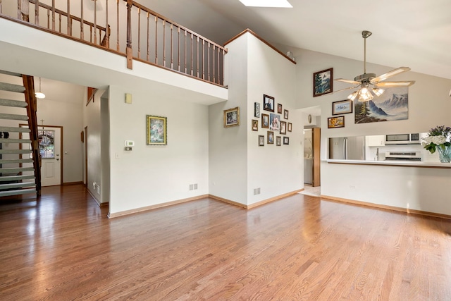 3072 Carlton Ct, Westchester, IL 60154 - unfurnished living room featuring high vaulted ceiling, wood finished floors, a ceiling fan, and stairs