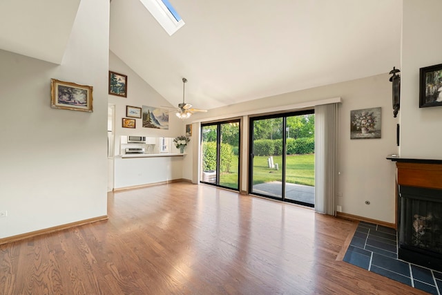 3072 Carlton Ct, Westchester, IL 60154 - unfurnished living room with high vaulted ceiling, wood finished floors, a fireplace with flush hearth, ceiling fan, and a skylight