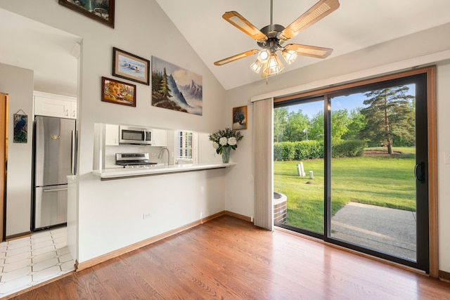 3072 Carlton Ct, Westchester, IL 60154 - kitchen featuring stainless steel appliances, white cabinets, a peninsula, high vaulted ceiling, and ceiling fan