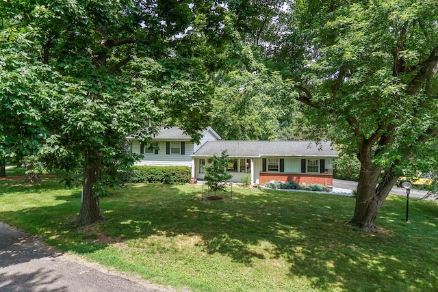 8524 Carriage Hills Rd, Bloomington, IL 61705 - split level home featuring a front lawn, a porch, roof with shingles, and brick siding