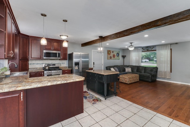 8524 Carriage Hills Rd, Bloomington, IL 61705 - kitchen with stainless steel appliances, light tile patterned floors, beam ceiling, decorative backsplash, and a peninsula
