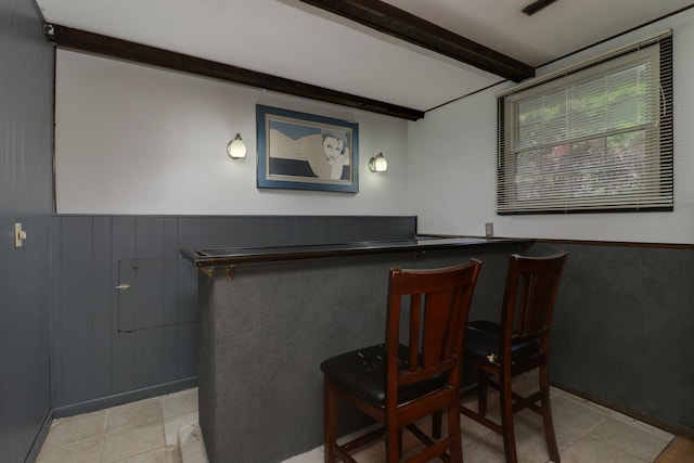 8524 Carriage Hills Rd, Bloomington, IL 61705 - indoor dry bar featuring beamed ceiling, light tile patterned flooring, and a wainscoted wall