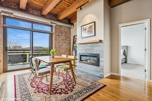 1735 W Diversey Pkwy Unit 402, Chicago, IL 60614 - dining area with wood ceiling with exposed beams, wood finished floors, a tiled fireplace, and baseboards