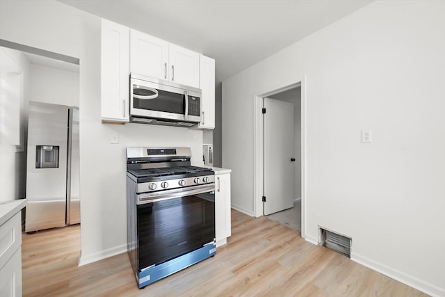 3633 N Lotus Ave, Chicago, IL 60641 - kitchen with appliances with stainless steel finishes, light wood finished floors, light countertops, and white cabinetry