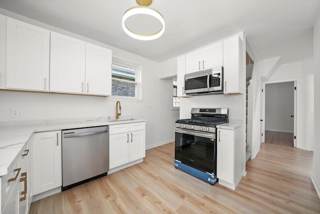 3633 N Lotus Ave, Chicago, IL 60641 - kitchen with stainless steel appliances, light wood-type flooring, white cabinetry, and light stone countertops