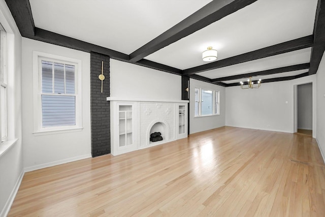 3633 N Lotus Ave, Chicago, IL 60641 - unfurnished living room with a chandelier, light wood-style floors, beamed ceiling, and a fireplace