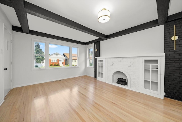 3633 N Lotus Ave, Chicago, IL 60641 - unfurnished living room with plenty of natural light, beam ceiling, light wood-style floors, a brick fireplace, and built in shelves