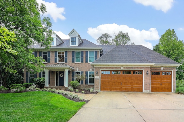 26W231 Tuckaway Ct, Winfield, IL 60190 - colonial home featuring a garage, brick siding, concrete driveway, and a front lawn