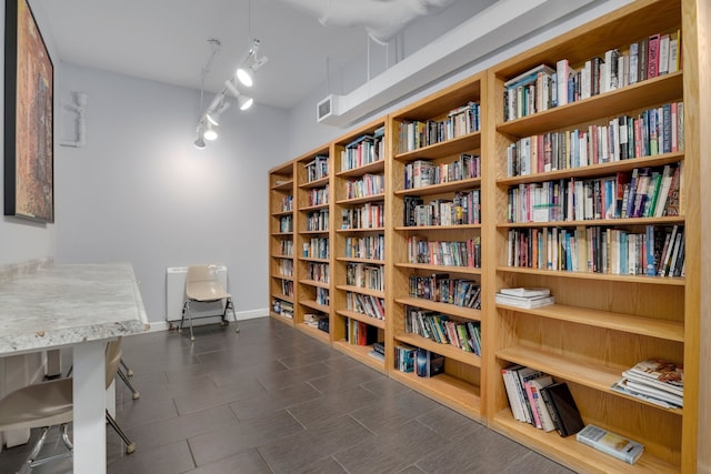 1550 N Lake Shore Dr Unit 9F, Chicago, IL 60610 - living area with wall of books, rail lighting, and baseboards