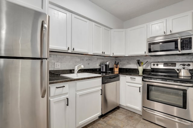 1550 N Lake Shore Dr Unit 9F, Chicago, IL 60610 - kitchen with stainless steel appliances, a sink, decorative backsplash, white cabinets, and a textured ceiling