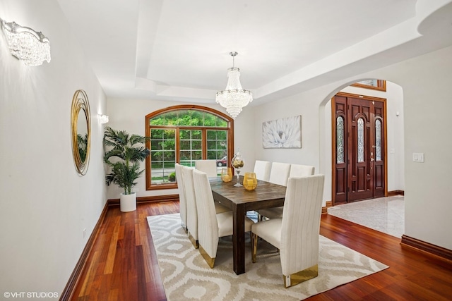 3832 W Chase Ave, Lincolnwood, IL 60712 - dining room with a tray ceiling, a chandelier, arched walkways, and wood finished floors
