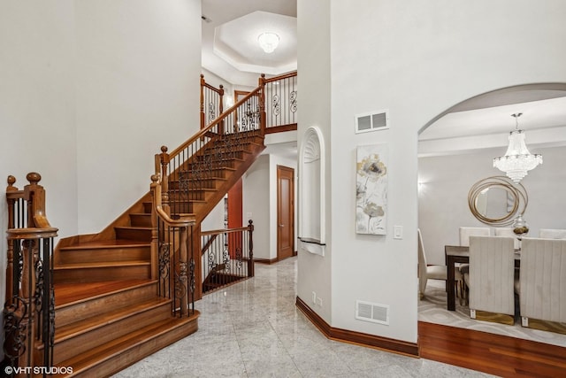 3832 W Chase Ave, Lincolnwood, IL 60712 - stairs with arched walkways, a chandelier, and a high ceiling