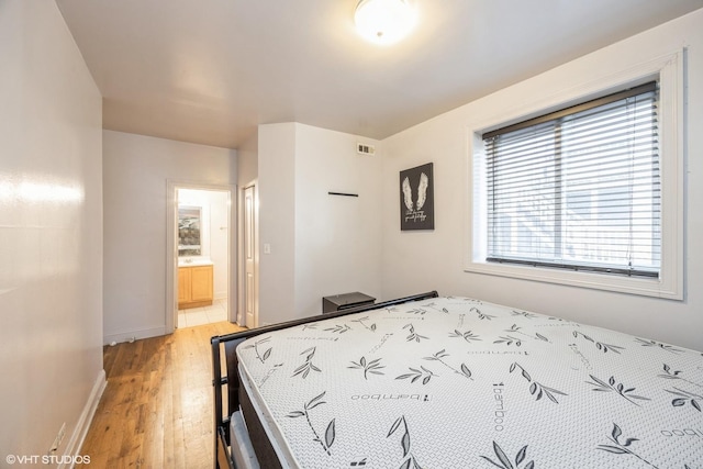 805 S Independence Blvd Unit 3, Chicago, IL 60624 - bedroom with light wood-style floors, ensuite bath, and baseboards