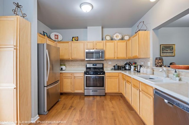 2402 Oakfield Ct, Aurora, IL 60503 - kitchen featuring appliances with stainless steel finishes, light brown cabinetry, a sink, light wood-type flooring, and backsplash