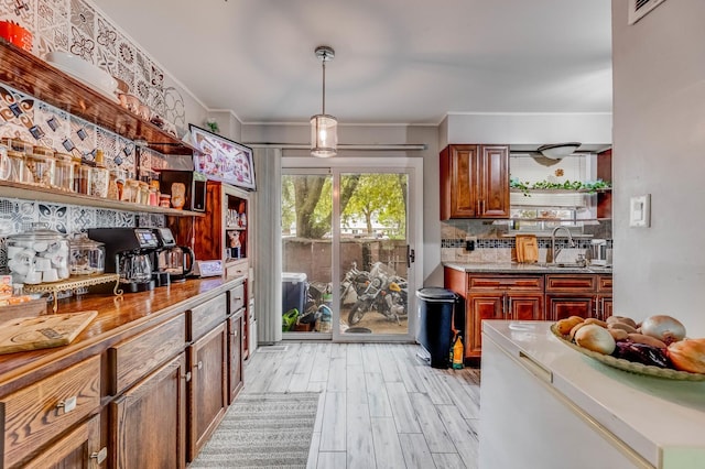 426 Greentree Ln, Bolingbrook, IL 60440 - kitchen with open shelves, light wood-style floors, decorative backsplash, decorative light fixtures, and a sink