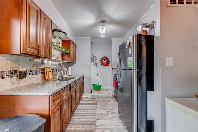 426 Greentree Ln, Bolingbrook, IL 60440 - kitchen with freestanding refrigerator, a sink, decorative backsplash, brown cabinetry, and light countertops