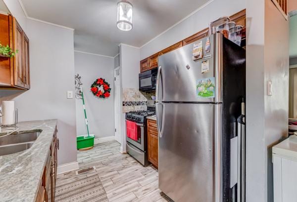 426 Greentree Ln, Bolingbrook, IL 60440 - kitchen featuring appliances with stainless steel finishes, brown cabinets, a sink, light wood-style flooring, and ornamental molding