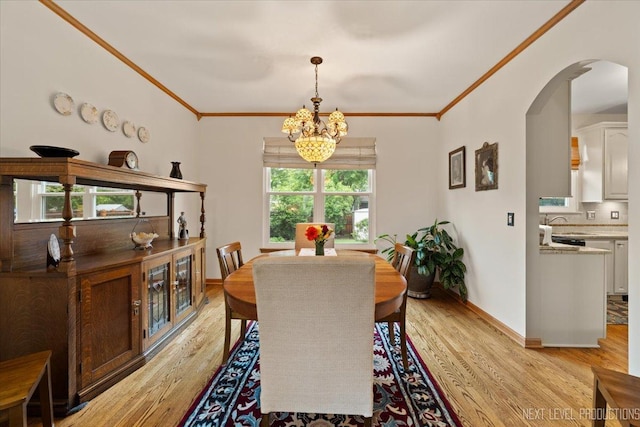 2937 Arbor Ln, Aurora, IL 60502 - dining space with arched walkways, a chandelier, light wood-type flooring, and ornamental molding