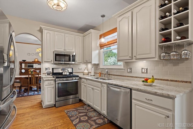 2937 Arbor Ln, Aurora, IL 60502 - kitchen with stainless steel appliances, backsplash, light wood-style floors, decorative light fixtures, and light stone countertops