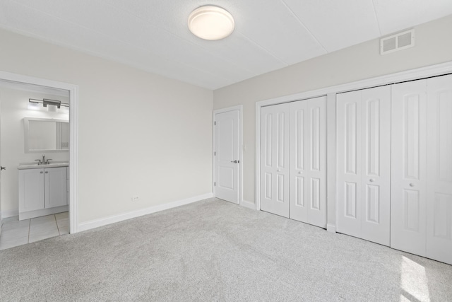 9431 S 79th Ave Unit 105N, Hickory Hills, IL 60457 - unfurnished bedroom featuring carpet flooring, multiple closets, a sink, baseboards, and connected bathroom