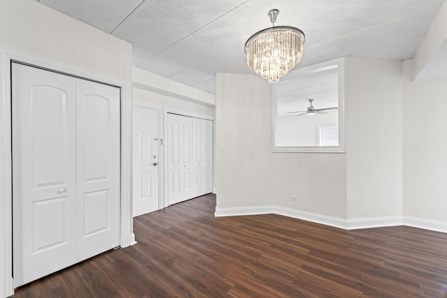 9431 S 79th Ave Unit 105N, Hickory Hills, IL 60457 - unfurnished dining area featuring dark wood-type flooring, a chandelier, baseboards, a ceiling fan, and a textured ceiling