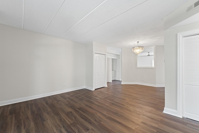 9431 S 79th Ave Unit 105N, Hickory Hills, IL 60457 - empty room featuring a chandelier, dark wood-type flooring, and baseboards