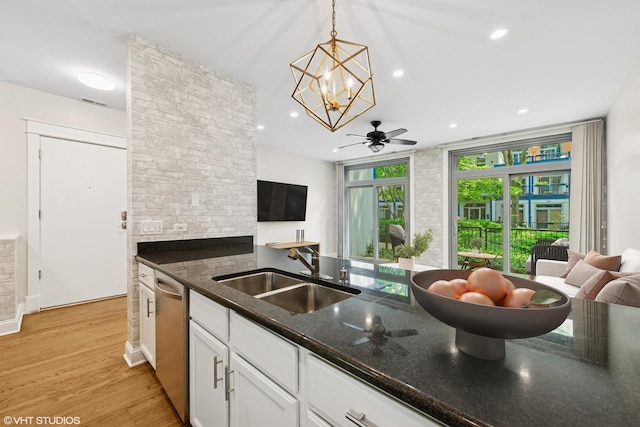 23 N Racine Ave Unit 405, Chicago, IL 60607 - kitchen with stainless steel dishwasher, white cabinets, dark stone countertops, a chandelier, and hanging light fixtures