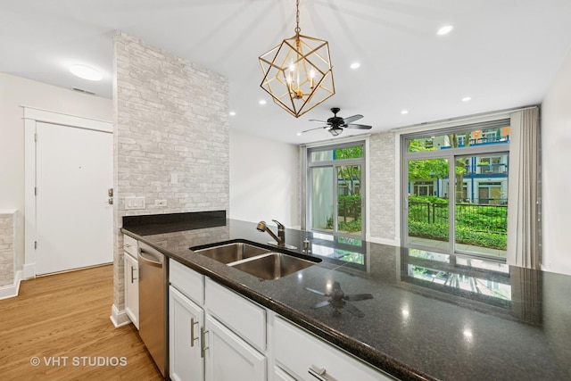 23 N Racine Ave Unit 405, Chicago, IL 60607 - kitchen with dishwasher, dark stone counters, ceiling fan, white cabinetry, and a chandelier