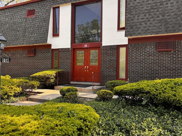 1015 Deerfield Rd Unit 132, Deerfield, IL 60015 - doorway to property with a shingled roof, brick siding, and mansard roof