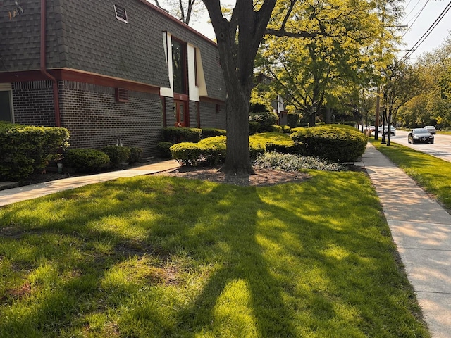1015 Deerfield Rd Unit 132, Deerfield, IL 60015 - view of property exterior with mansard roof, brick siding, roof with shingles, and a yard