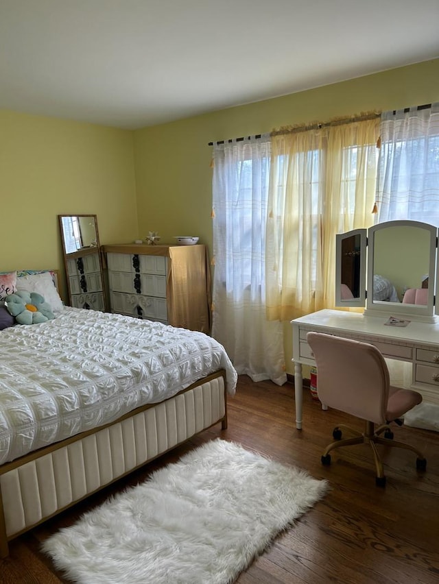 bedroom with wood finished floors and a desk