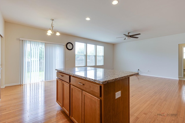 3452 Birch Ln, Naperville, IL 60564 - kitchen with brown cabinetry, a center island, light wood finished floors, ceiling fan, and open floor plan